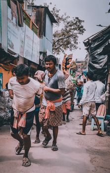 Men walking through a bustling street in Kolkata, showcasing the vibrant local culture.