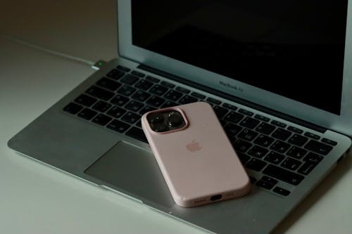 Free Pink Smartphone on Laptop Stock Photo