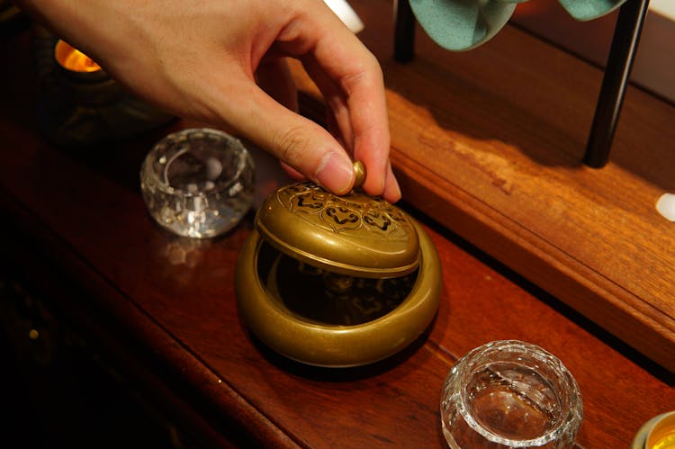 Close-up Of Person Hand Opening Vintage Container