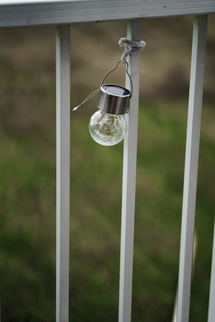 Bulb Hanging On A Metal Fence