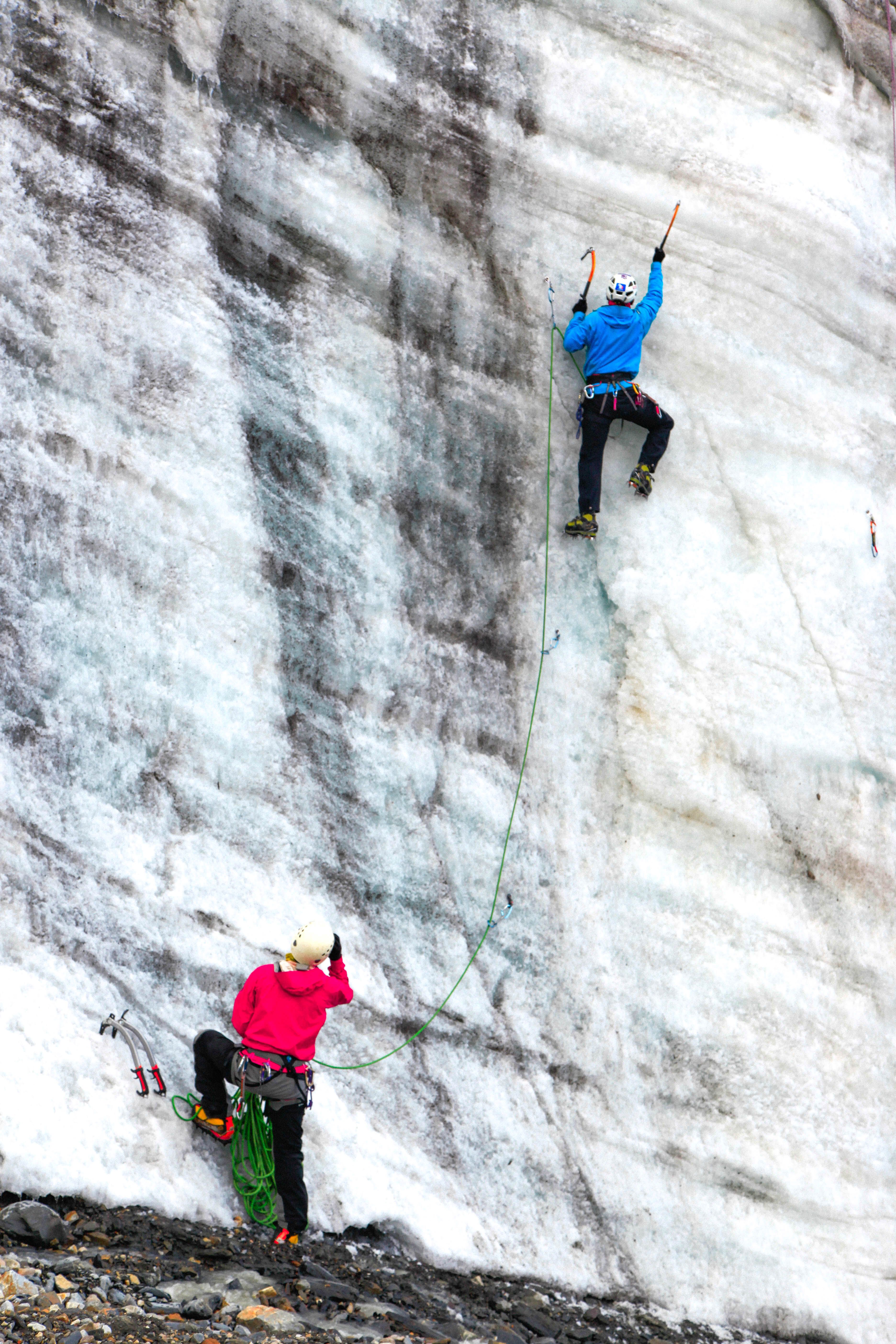 Two climbers traverse a frozen wall in Manang, Nepal, showcasing strength and courage.