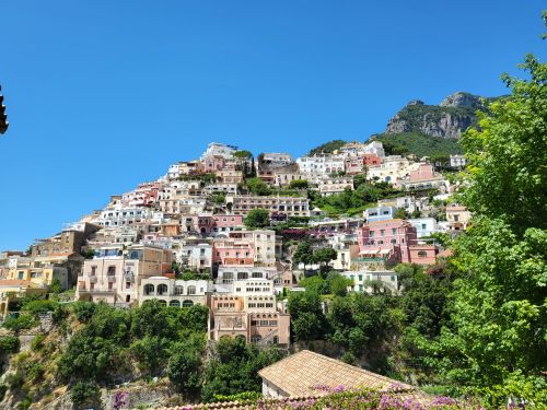 Free Picturesque landscape of Positano village with colorful buildings under a clear blue sky. Stock Photo