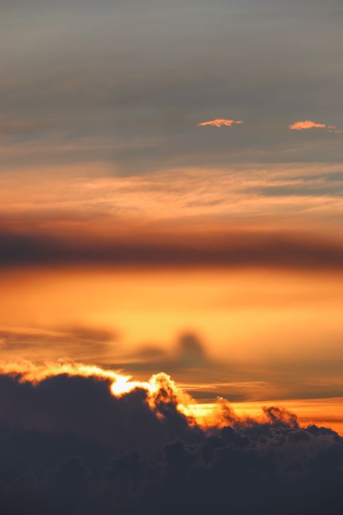 Free Stunning sunset with golden clouds creating a dramatic skyline. Stock Photo