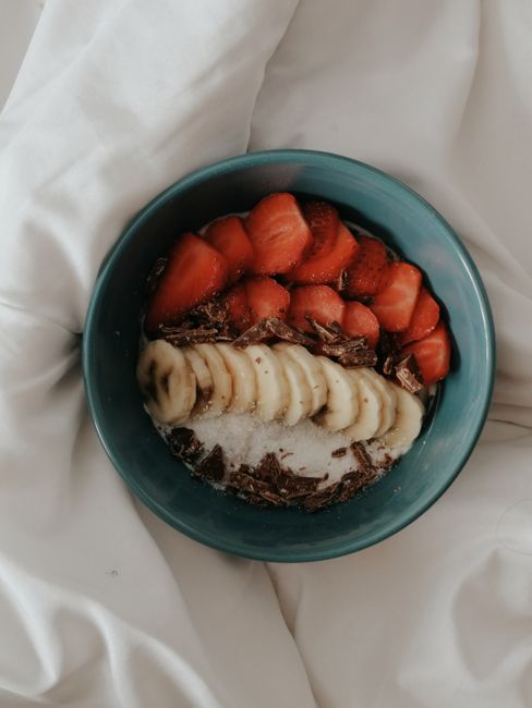 A delicious homemade breakfast bowl with fruits and chocolate on a cozy setting.