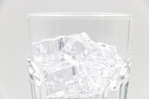 Free Close-up of transparent ice cubes inside a sparkling glass against a light background. Stock Photo