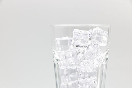 Free Close-up of a glass filled with ice cubes on a white background. Stock Photo