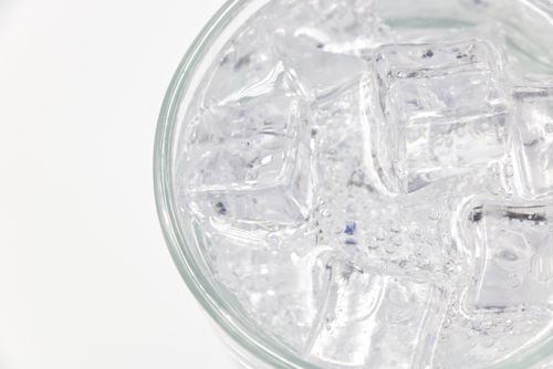 Free A refreshing top view of ice cubes in a glass filled with effervescent sparkling water. Stock Photo