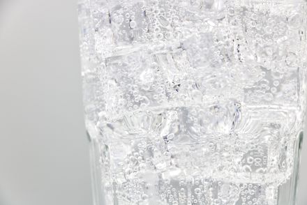 Cooling beverage with fizzy bubbles and ice cubes in a clear glass — photo by Srattha Nualsate on Pexels
