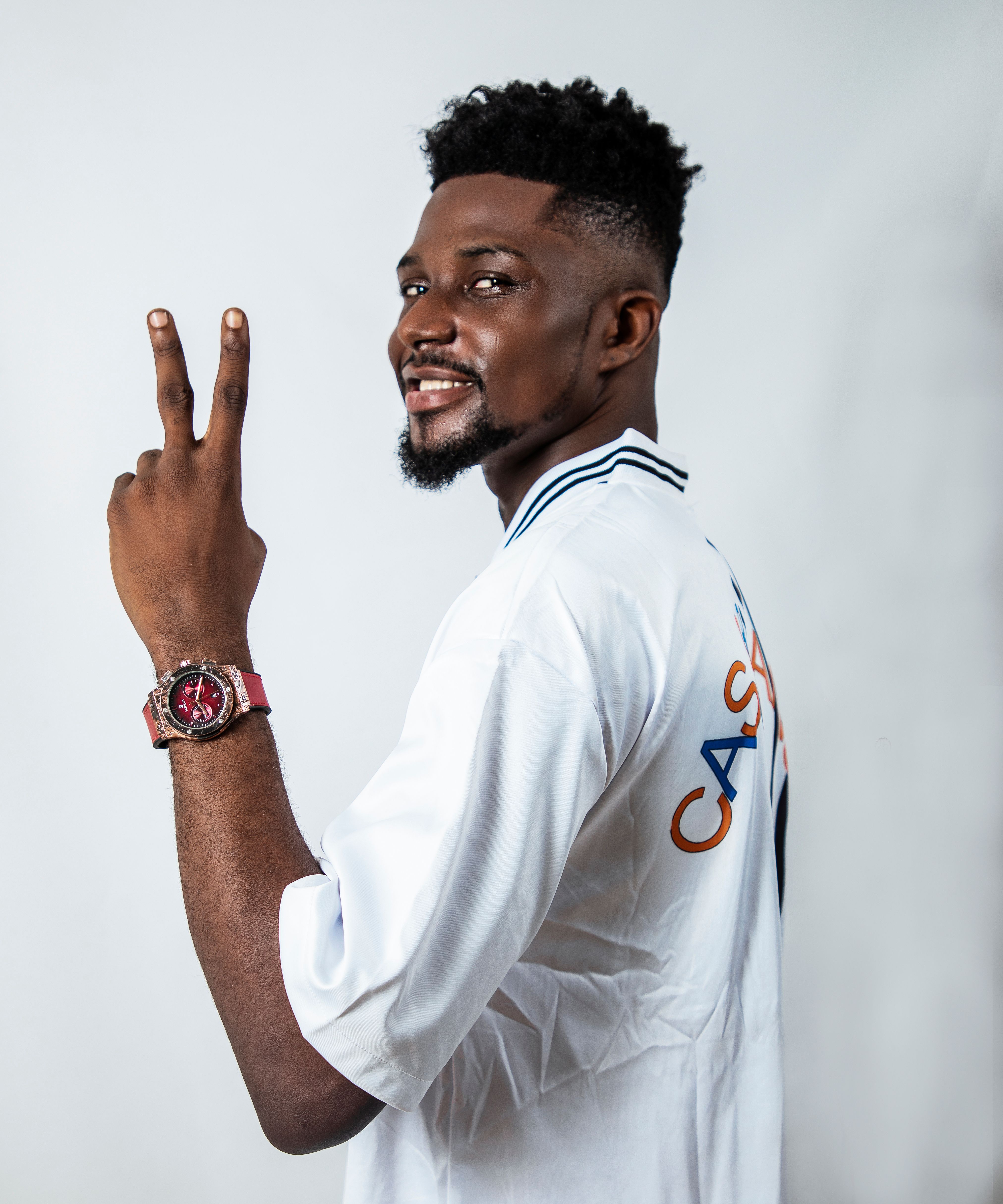 Portrait of a cheerful man showing a peace sign in a studio in Lagos, Nigeria.