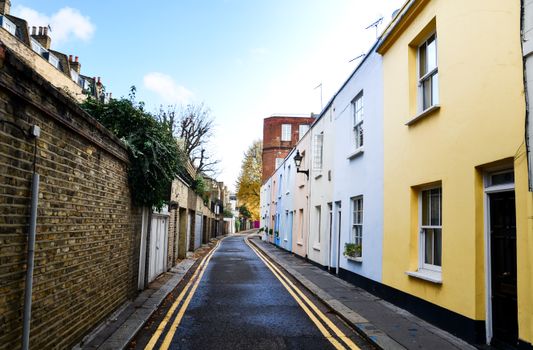 Colorful narrow street in Notting Hill, London, showcasing vibrant facades and quaint architecture.