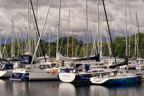 Free A picturesque scene of sailboats docked at a serene marina under a cloudy sky in Germany. Stock Photo