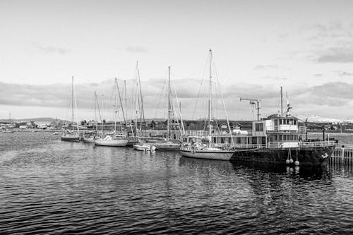 Grayscale Photo of Boats on the Ocean