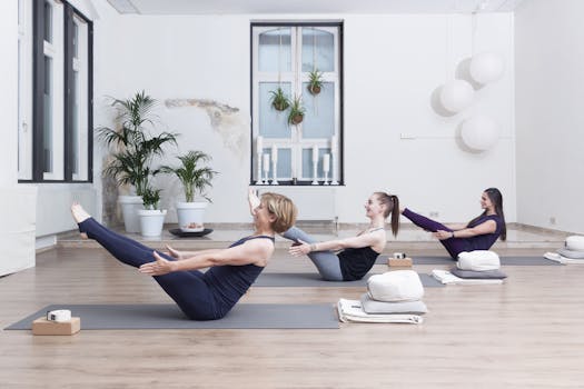 Adult women practicing yoga in a bright studio, focused on relaxation and wellness.
