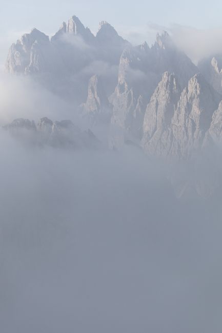 Foggy view of the majestic Dolomite mountains in Veneto, Italy, enveloped in mist.