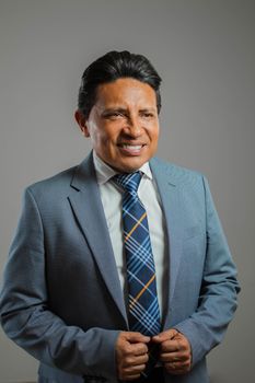 Confident businessman smiling in a blue suit with a plaid tie.