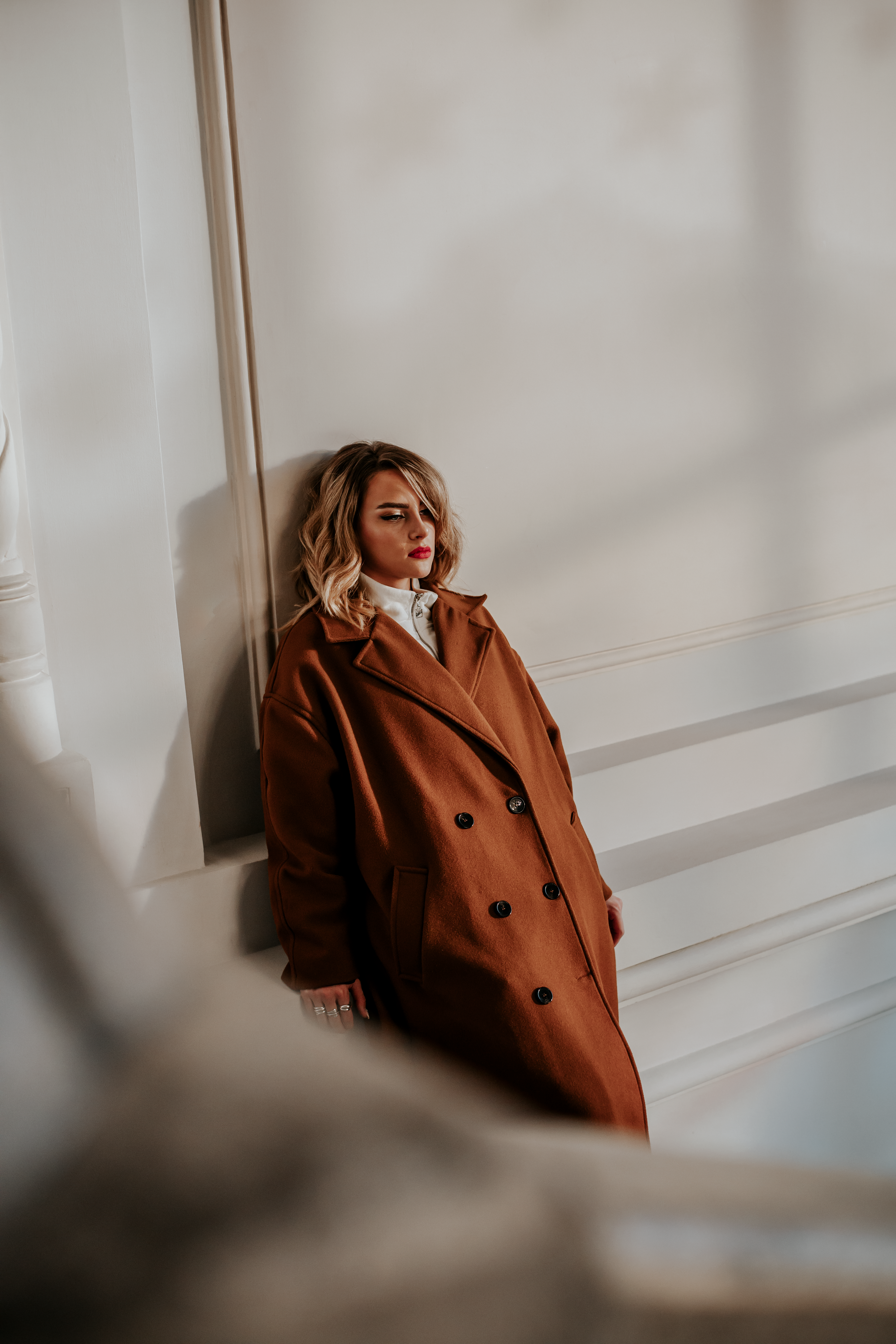 Woman in Brown Coat Leaning on a Wall · Free Stock Photo
