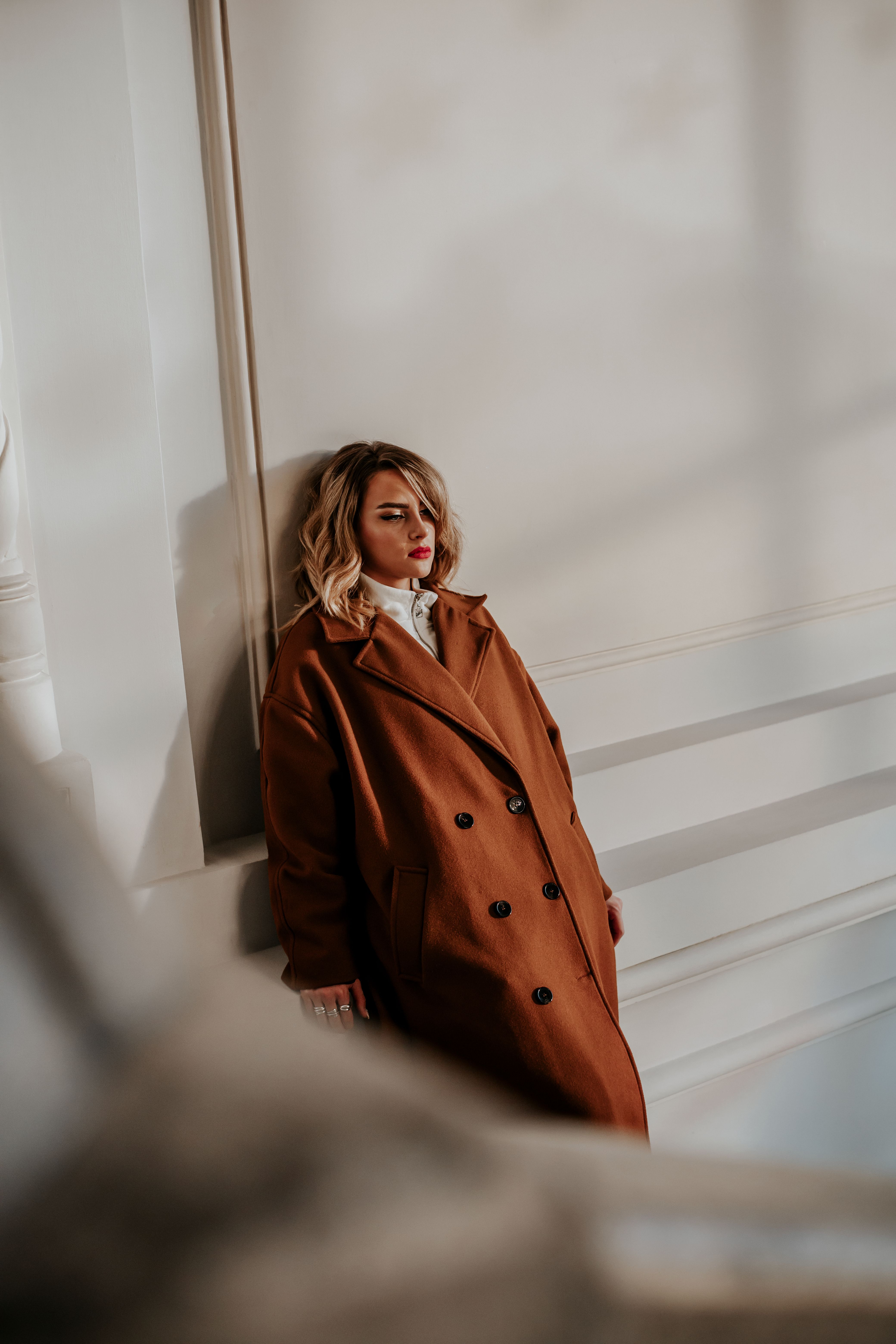 Woman in Brown Coat Leaning on a Post · Free Stock Photo