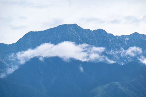 Free Captured mountain peaks with floating clouds and fog on a serene day. Stock Photo