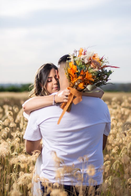 Free A Couple Hugging in the Grass Field Stock Photo