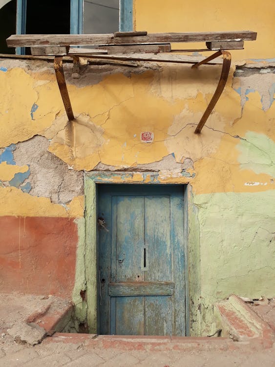 Free Blue Wooden Door on Yellow Concrete Wall Stock Photo