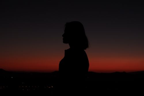 Free Silhouette of a woman against a vibrant sunset sky in Nevşehir, Türkiye. Stock Photo