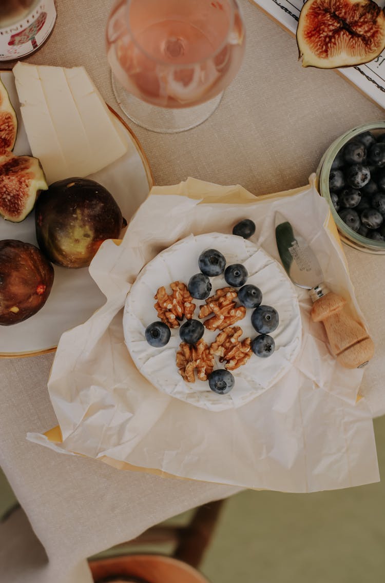 Brie With Fruits And Wine On Table