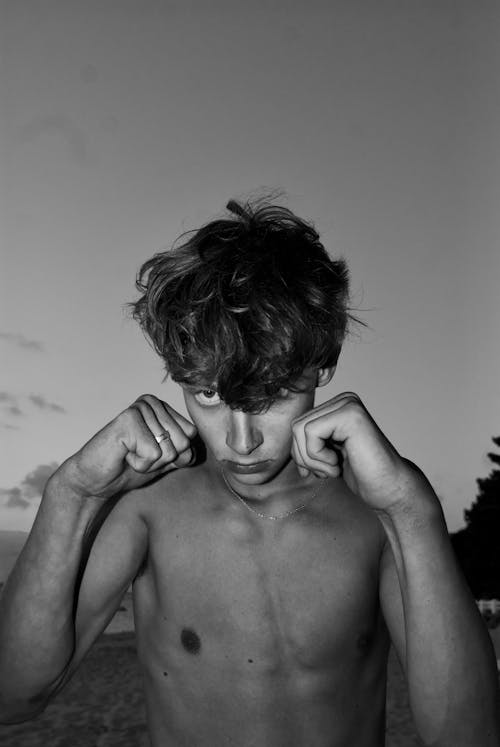 Grayscale Photo of a Topless Young  Man with a Boxing Hand Gestures