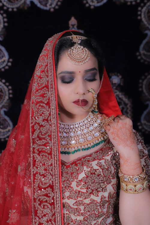 Free Beautiful Indian bride wearing traditional red attire with intricate jewelry and henna tattoo. Stock Photo