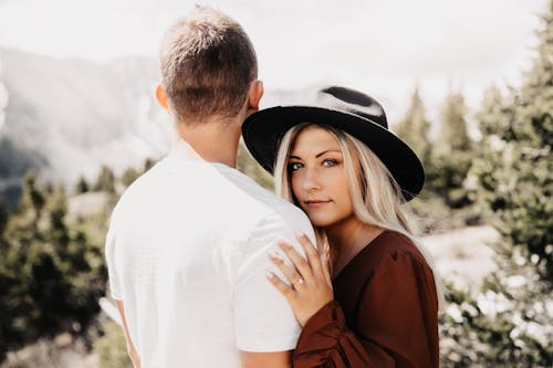 A Woman in Brown Long Sleeves Embracing Her Partner