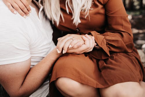 Woman and Man Sitting and Holding Hands