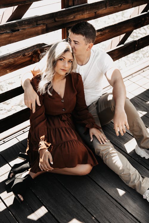 Free High Angle View of a Couple Sitting on a Wooden Terrace Stock Photo