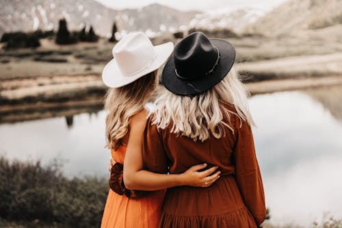 Friends Embracing Each Other by Lake Shore