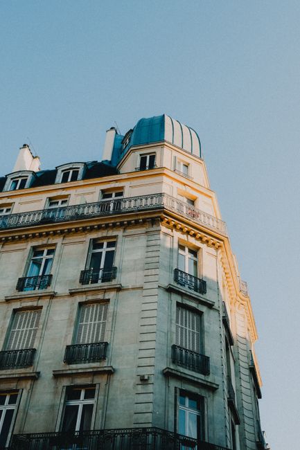 Low-angle shot of a classic Parisian building exterior with beautiful sunset lighting.