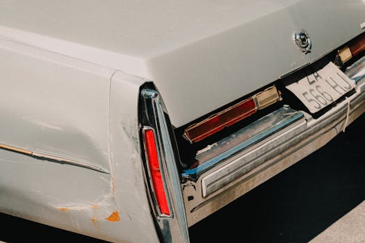 Rear view of a classic vintage car showcasing its tail light and retro license plate.