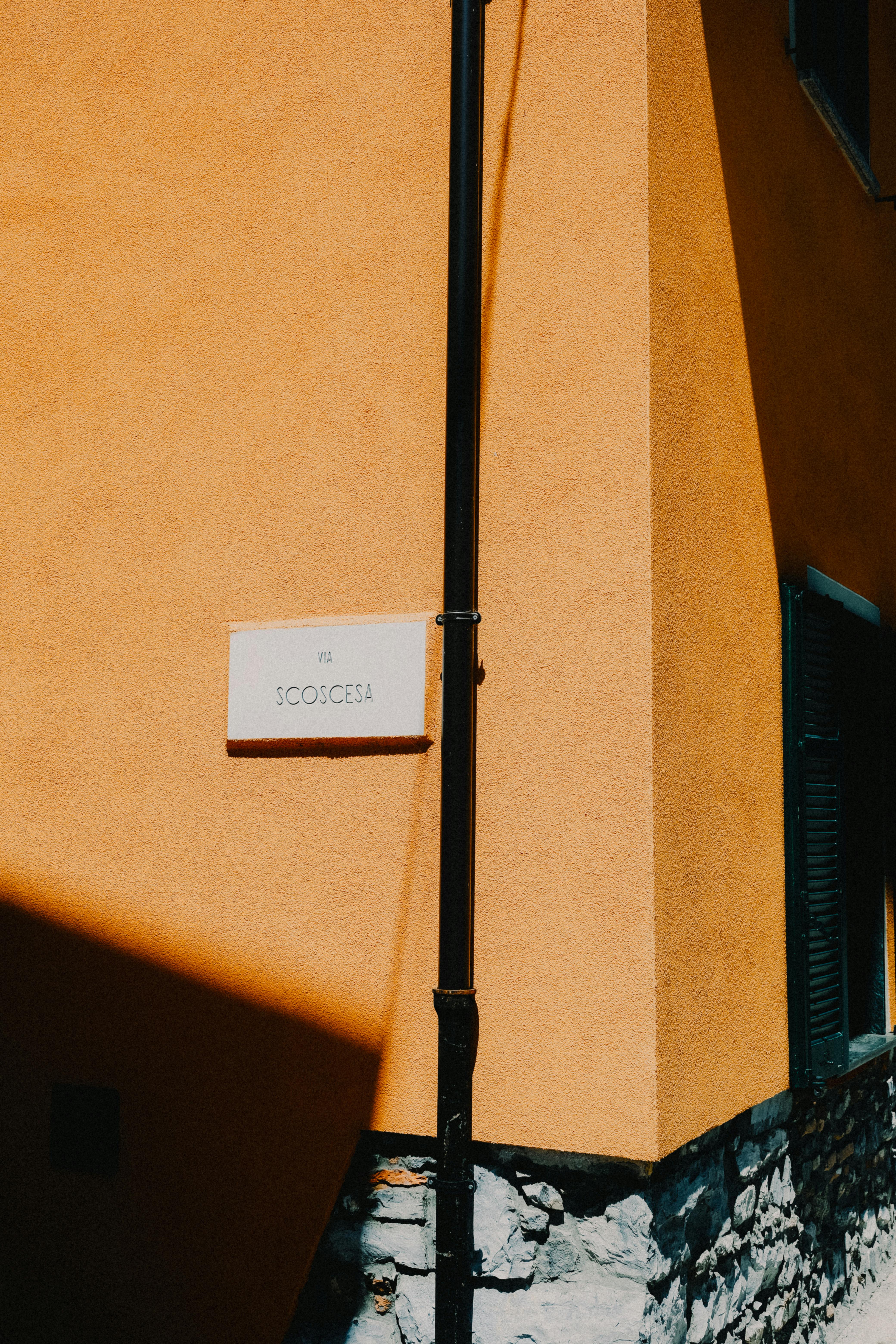 Brightly lit building corner with shadows casting a dynamic facade.
