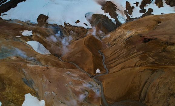 A breathtaking aerial view of Iceland's mountainous highlands, featuring snow and rivers.