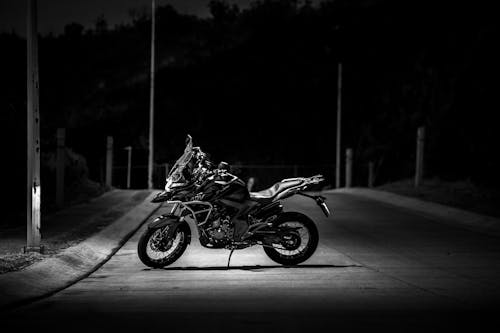 Grayscale Photo of a Motorcycle Parked on the Road