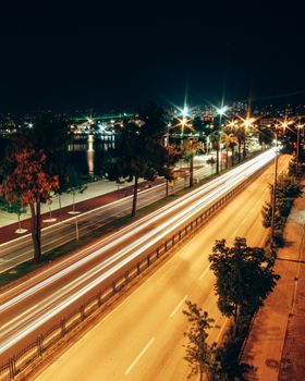 Long exposure image capturing dynamic night traffic on a city road with light trails.