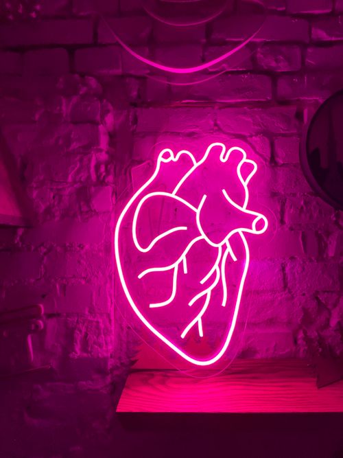 Free Glowing pink neon heart sign on a brick wall in Kyiv, Ukraine. Stock Photo