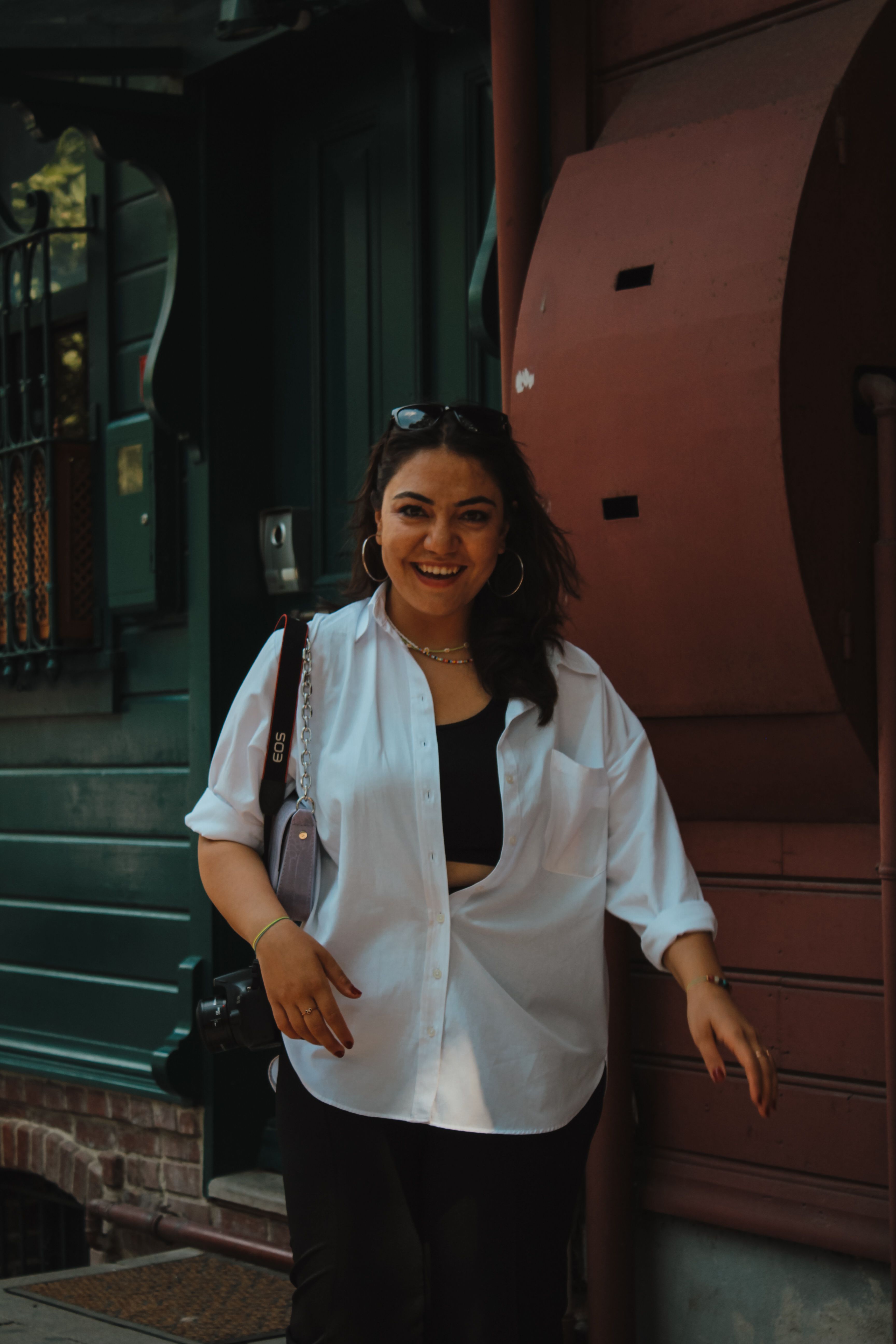 Young woman in a casual outfit smiling on a street in Istanbul.