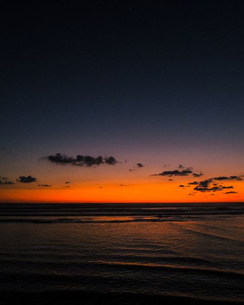 Free A beautiful sunset over the seascape in Acapulco, Mexico, featuring vivid orange hues and gentle waves. Stock Photo