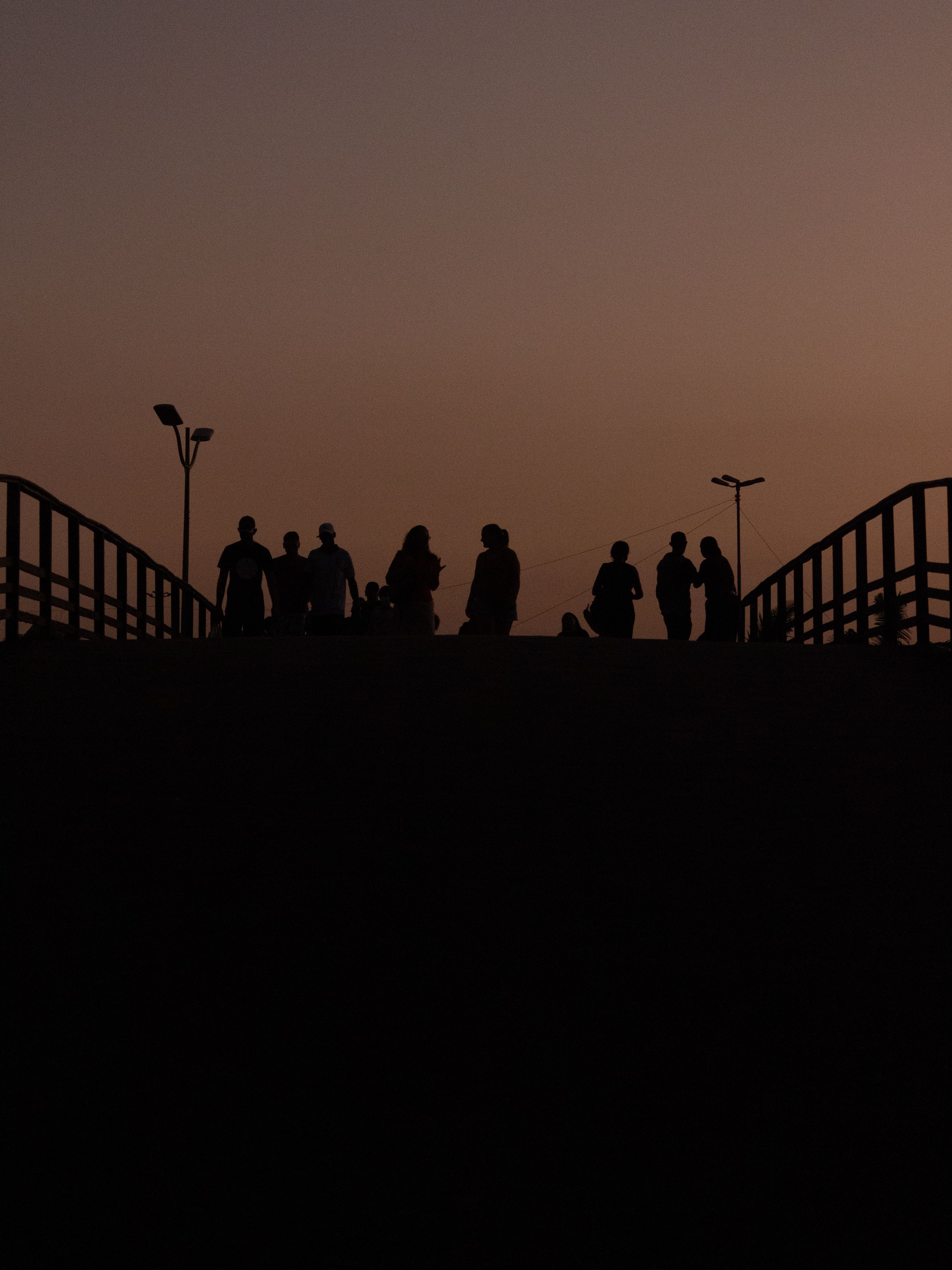 Silhouette of People Standing on Bridge at Dusk · Free Stock Photo