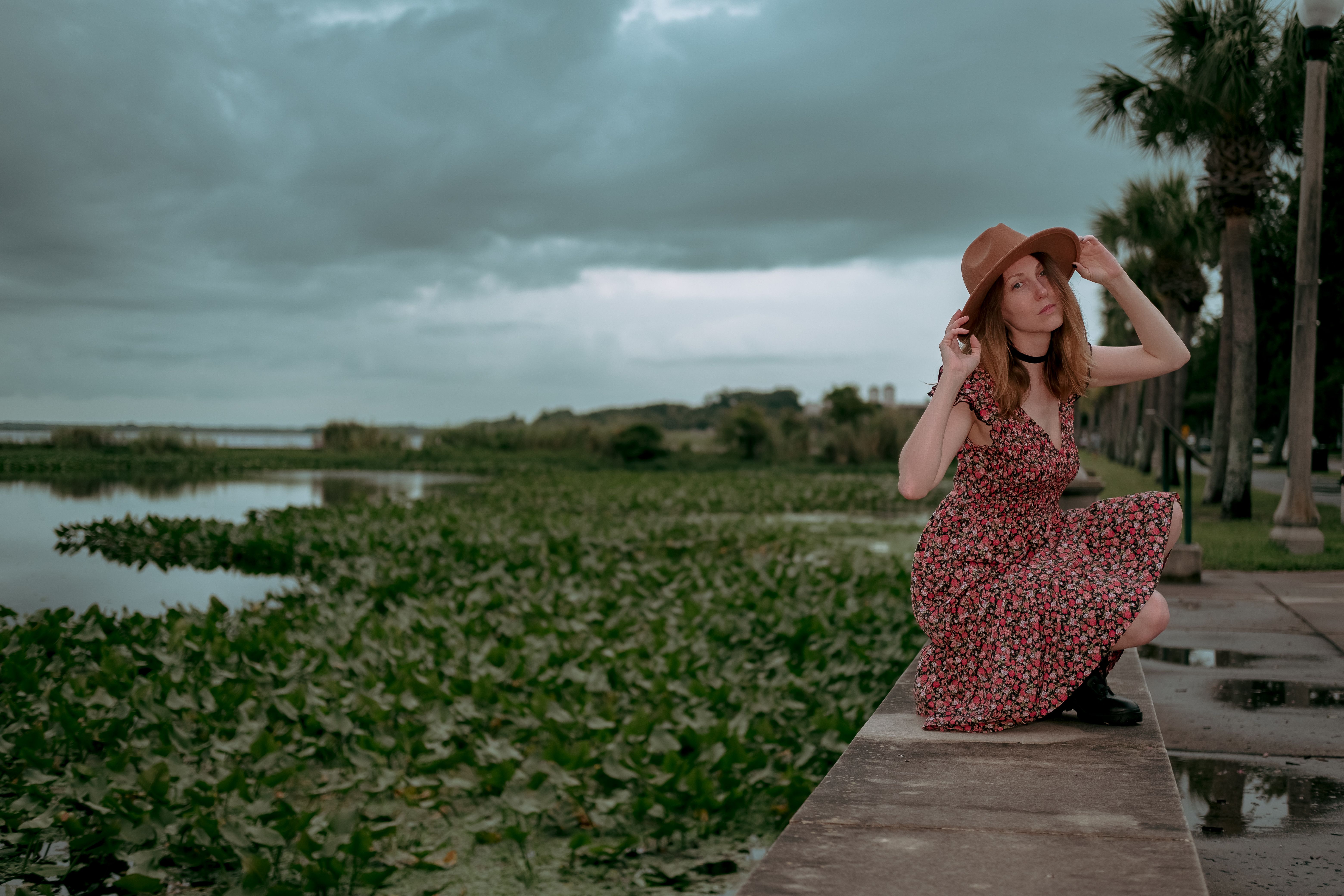 Woman in Printed Dress Standing Beside a Body of Water · Free Stock Photo