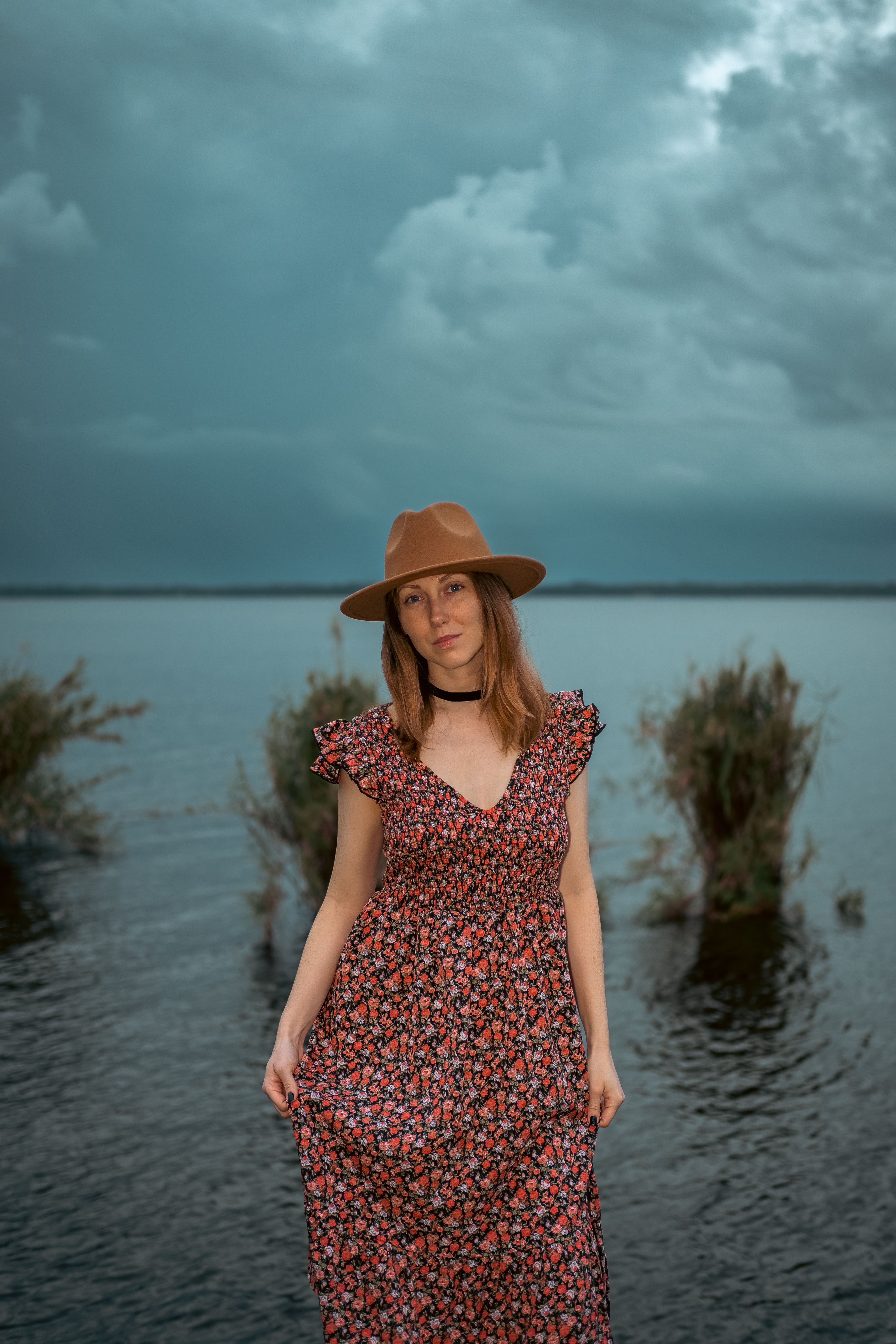 Woman in Printed Dress Standing Beside a Body of Water · Free Stock Photo