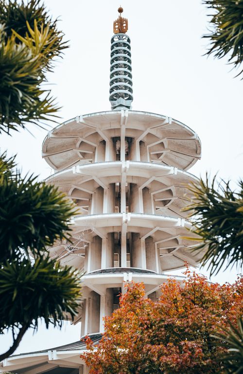 Free A striking view of the Peace Pagoda in San Francisco, framed by lush foliage in fall. Stock Photo