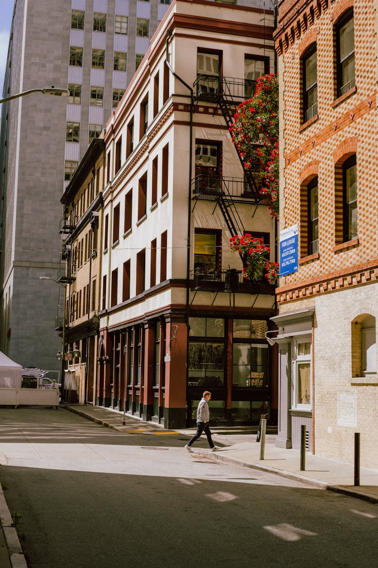 A Man Walking On A Street In A City