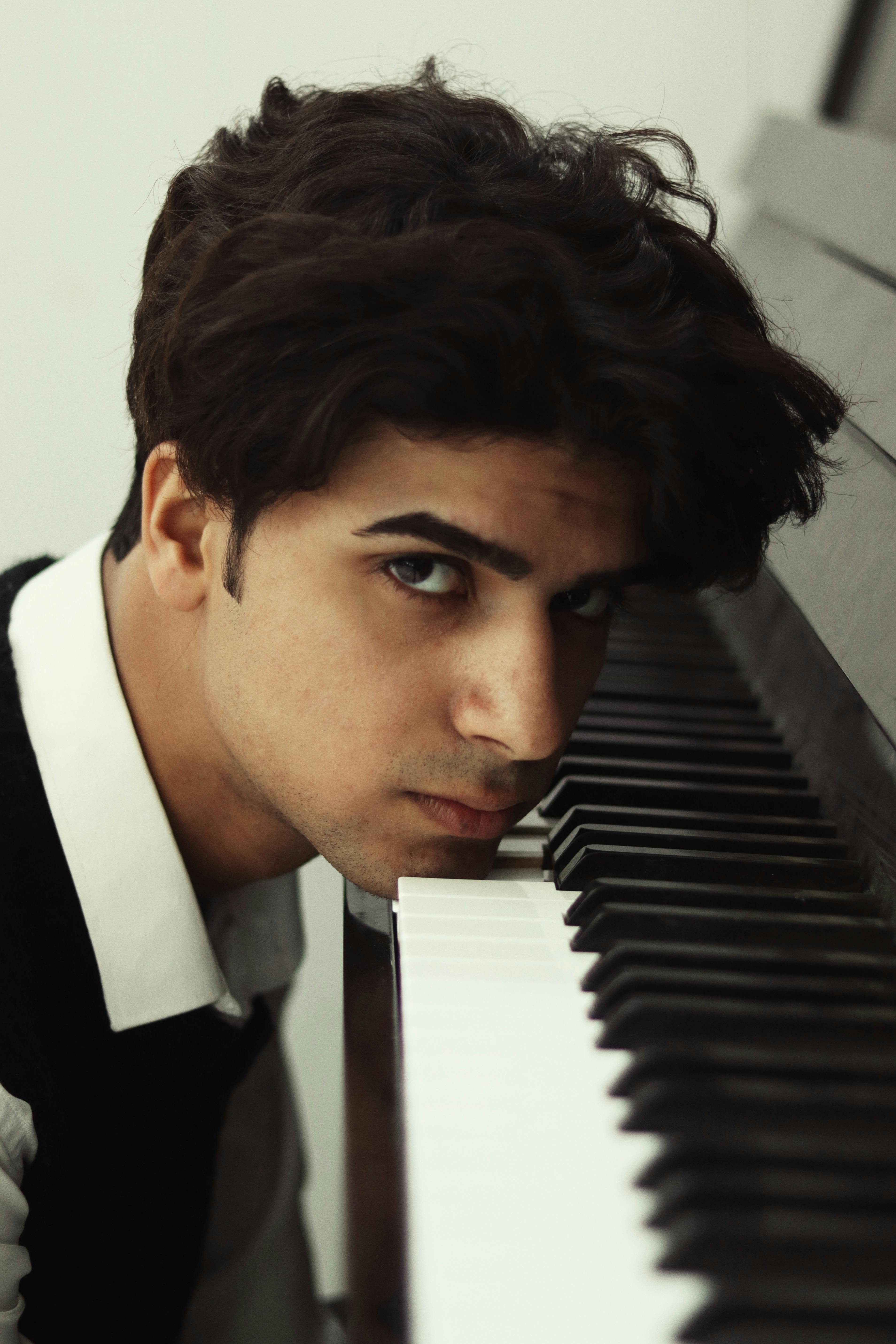 portrait of man lying head on piano