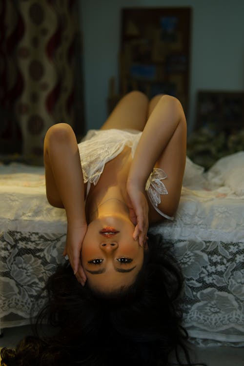 Woman in White Tank Top Lying on Bed