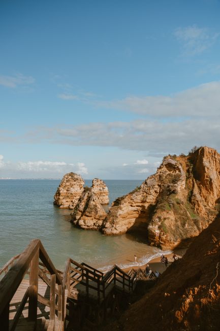 Explore breathtaking rock formations by the seaside under a clear blue sky.