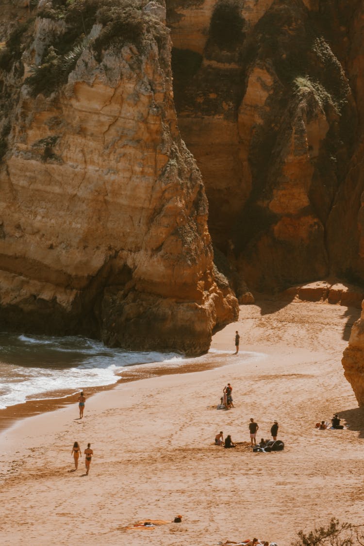 People On Sea Sand Beach Near Cliffs